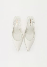 Valkoiset slingback-kengät, joissa on terävä kärki, sileä nahkapinta ja huomaamaton brändimerkintä sisäpohjassa. Säädettävä solki varmistaa mukavan istuvuuden.