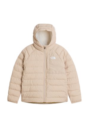 Enfant portant une veste matelassée beige, des leggings bordeaux, des chaussettes beiges et des bottes, tenant un sac à dos marron et portant des lunettes de soleil noires.