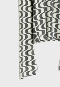 Wellig gemusteter Stoff in Schwarz und Weiß mit einer weichen Textur. Das Design umfasst abwechselnde Kurven und gerade Kanten.