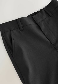 Schwarze, taillierte Hose aus glattem Material, mit flachem Bund, gefaltetem Vorderteil und seitlichen Taschen. Das Design legt Wert auf Komfort und Passform.