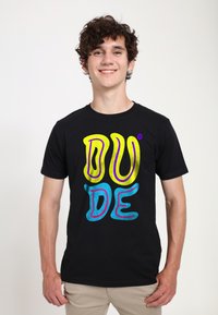 Černé tričko s výrazným, barevným textovým designem, které obsahuje slovo "DUDE" ve žluté, růžové a modré barvě s lesklým vzhledem.
