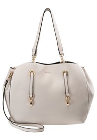 Kermainen, teksturoidusta nahasta valmistettu laukku, jossa on kaksi yläkahvaa, kultasävyinen metalli ja irrotettava olkahihna valkoista taustaa vasten.