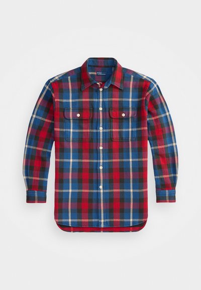 Red, blue, and black plaid flannel shirt with long sleeves, two front pockets, rounded hem, and button-down collar. Textured fabric.