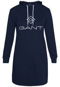 Donkerblauwe hoodie jurk van lichtgewicht stof, met een groot wit "GANT" logo, een voorzak en een capuchon met trekkoord.