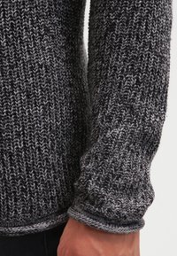 Strickpullover mit einem strukturierten, melierten Muster in Grautönen. Mit gerippten Bündchen und Saum sowie einem lässigen Schnitt.