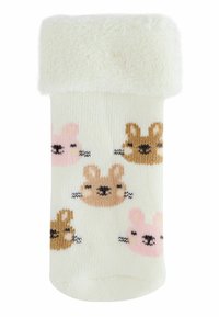Chaussette blanche pour tout-petit avec un rebord replié, ornée d'un motif de visages de lapins souriants dans des couleurs rose, beige et marron.