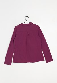 Maglietta a maniche lunghe viola con colletto, dettaglio di piega sul retro e bottoni decorativi sulle maniche. Realizzata in tessuto morbido con una vestibilità comoda.