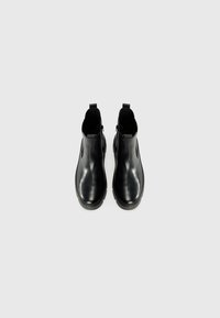 Zwarte leren enkelboots met elastische zijpanelen, een ronde neus en een platte rubberen zool. Glad oppervlak met een minimalistisch ontwerp.