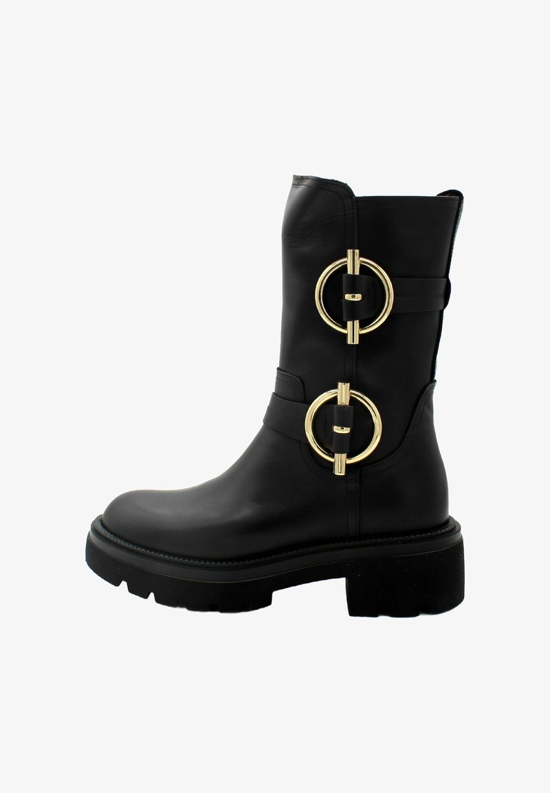 Stivale alla caviglia in pelle nera con due accessori circolari in oro, tacco chunky e suola testurizzata. Design elegante con dettagli di cuciture minime.