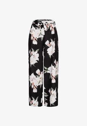 Fekete anyagból készült, bőszárú virágos nadrág, nagy fehér és rózsaszín virágmintákkal, megkötős derékrésszel a szabás állíthatóságáért.