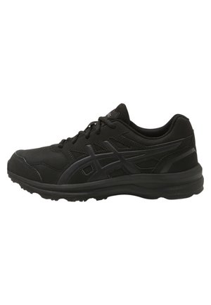 Black low-top athletic shoe with lace-up closure, textured sole, and subtle brand logo stripes on the side.