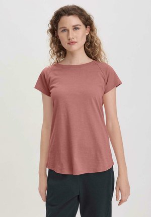 T-shirt a maniche corte, collo rotondo, di un colore rosa tenue, realizzato in un tessuto morbido con una vestibilità rilassata, con dettagli di cucitura discreti.