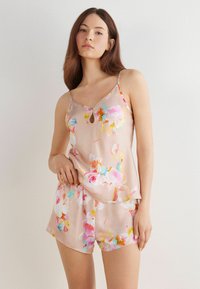 Floral pyjamaset met een lichtroze satijnstof. Het camisole heeft dunne schouderbanden en een sleutelgatdetail; de shorts hebben een bijpassende bloemenprint.