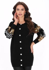 Cardigan lung negru cu mâneci împodobite cu paiete aurii și negre strălucitoare, cu nasturi argintii în față și decolteu rotund.