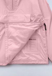 Ροζ μπουφάν Napapijri με μερικό άνοιγμα στο φερμουάρ, αποκαλύπτοντας εσωτερική τσέπη με ετικέτα της μάρκας και εικονίδια που υποδεικνύουν ραφές με ταινία σφράγισης, διαπνεόμενο ύφασμα, αντοχή στο νερό και δυνατότητα συσκευασίας.