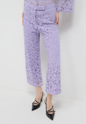 Lila Spitzen-weitbeinige Hosen mit komplexen Blumenmustern, einer hohen Taille und verkürzter Länge, kombiniert mit schwarzen Lackleder-Absätzen.