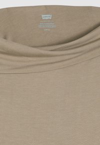 Μπεζ T-shirt μ ε ριμπ λαιμόκοψη. Κατασκευασμένο από μαλακό ύφασμα, με ομαλή υφή και εσωτερική ετικέτα με το λογότυπο του brand στον λαιμό.