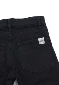 Svarta denimjeans med rak passform, två bakfickor med en märkesetikett och synliga stygn. 