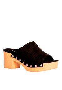 Zueco abierto de ante negro con tacón de madera, adornado con tachuelas metálicas en el borde. Diseño curvado, textura resistente y estructura de tacón cuadrado.