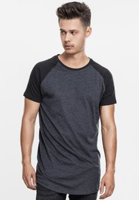 Dark gray raglan t-shirt featuring black short sleeves, a crew neckline, and a relaxed fit. Lightweight fabric with a smooth texture.