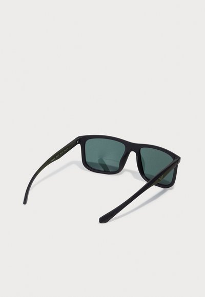Ochelari de soare negri cu lentile rectangulare, lentile verzi cu tenta, finisaj mat și brațe negre cu detalii subtile de branding.