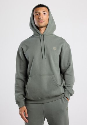 Olijfgroene hoodie van stevig materiaal, met een kangoeroezak, een capuchon met trekkoord en een klein logo-oppak op de borst.