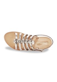 Sandal beige con cinturini in metallo argentato, suola piatta, design aperto e fibbia regolabile alla caviglia. Materiale in pelle morbida.