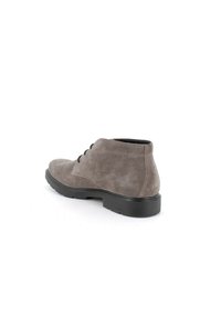 Stivale alla caviglia in suede grigio con punta rotonda, tre occhielli per i lacci e suola in gomma nera con texture. Design pulito e minimalista.