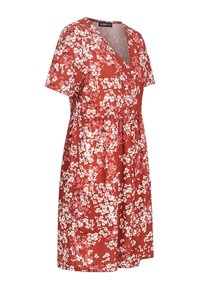 Punainen kukkamekko, jossa on lyhyet hihat, V-aukko, joustava vyötärö ja taskut. Mekossa on pieniä valkoisia ja vaaleanpunaisia kukkakuoseja teksturoidulla kankaalla.