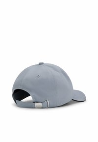 Grå baseballkeps med textilstruktur, justerbart band med metallspänne och rundad krona med en liten knapp på toppen.