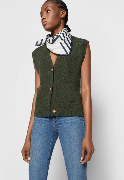 Colete verde tricotado sem mangas com decote em V, botões frontais e dois bolsos laterais, combinado com um cachecol listrado em branco e azul-marinho.