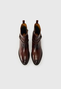 Bottines en cuir marron avec une finition texturée, un bout pointu, une fermeture éclair sur le côté et un accent en boucle près de la cheville.