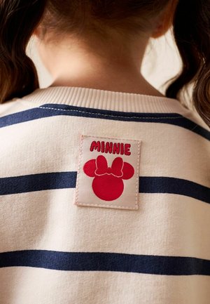 Cămașă cu dungi în culori bleumarin și crem, având o aplică de material roșu cu inscripția "MINNIE" și o siluetă a personajului Minnie Mouse. Textură moale, decolteu rotund.