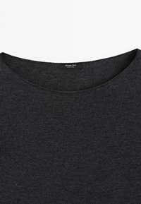 Pull à col rond gris foncé, en vue plat, avec une étiquette indiquant "Massimo Dutti" et "Fabriqué en Chine". Tissu texturé visible.