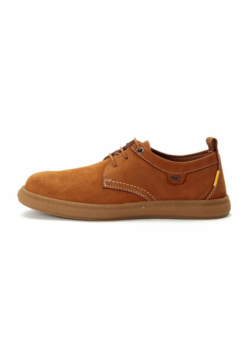 Zapatos de ante marrón con cordones, punta redondeada, costuras en contraste y suela de goma flexible. Incluye un sutil detalle de logo en el costado.