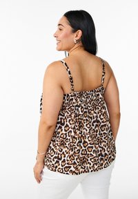 Top in stampa leopardata con spalline sottili, schiena arricciata e un tessuto leggero e texture in colori crema, marrone e nero.