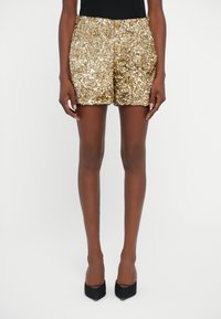 Gold sequin shorts with a straight cut, featuring a smooth texture and shiny finish. The design has a snug fit and a mid-rise waist.