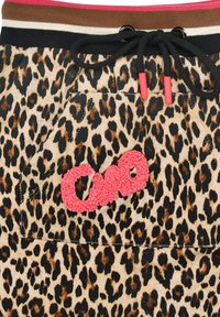 Leopardenmuster-Shorts mit einem braunen, schwarzen und pinken gestreiften Bund, ausgestattet mit einem roten gestickten Logo und einer Fronttasche.