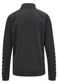 Veste noire à manches longues avec une surface texturée, un col haut et des accents en zigzag contrastants sur les manches. Le matériau semble flexible et respirant.