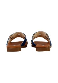 Blauwe suède sandalen met tan leren zolen, achteraanzicht toont twee verstelbare banden en een gewatteerde binnenzool. Rond vorm, minimalistisch ontwerp.