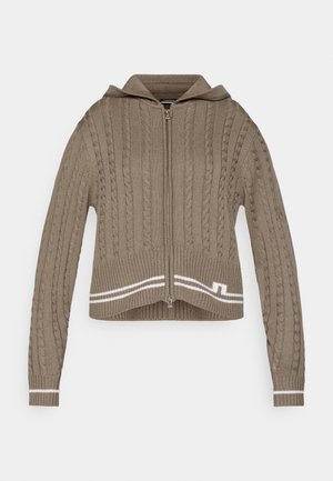 Beige kötött kapucnis felső, fonott mintával, teljes hosszúságú cipzárral és bordázott mandzsettával. Az alján fehér csíkokkal és kapucnival rendelkezik.