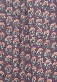 Tissu violet avec un motif répétitif de fleurs jaunes et roses avec des feuilles vertes disposées en rangées verticales.