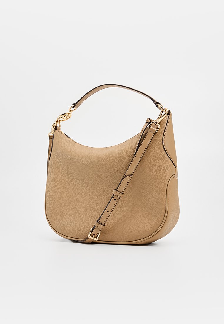 Bolso de mano de cuero beige con una textura suave, forma curvada, detalles en dorado, correa ajustable y un asa superior.