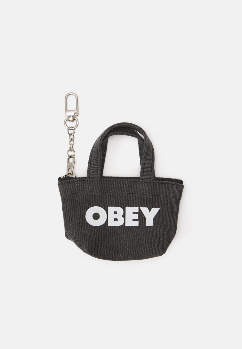 Piccola borsa tote in denim nero con cerniera, caratterizzata da testo bianco "OBEY" sul fronte e due manici corti. Include un attacco con clip in metallo.