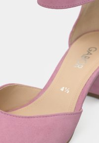 Ροζ σουέντ σανδάλι με ψηλό τακούνι, ανοιχτή μύτη και σχέδιο με κοψίματα, με μπεζ εσωτερική σόλα που φέρει την ένδειξη "GABOR" και μέγεθος παπουτσιού "4 ½".