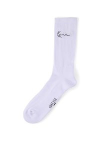 Weißer Sportsocken mit geripptem Muster, schwarzem kursivem Logo nahe der Manschette und schwarzem Aufdruck "EST 1989" auf der Fußsohlenseite.