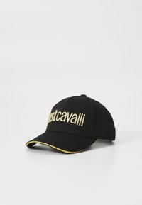 Black baseball cap with embroidered "justcavalli" logo in gold. Features a curved brim and yellow accent along the brim edge. Cotton material.