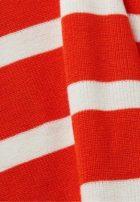 Strickstoff mit abwechselnd breiten orangefarbenen und weißen Streifen. Die Textur ist gerippt und verleiht ein strukturiertes Erscheinungsbild.