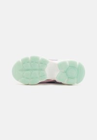 Semelle de chaussure de sport en blanc et vert menthe, présentant des motifs de traction distincts et un design rembourré pour le confort.