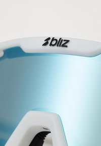 Les lunettes de sport Bliz présentent une monture blanche, des verres teints en bleu et un design élégant. Les verres ont une finition légèrement réfléchissante et une texture lisse.